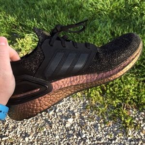 Black adidas shoes with a gold like shimmer and a rose gold bottom